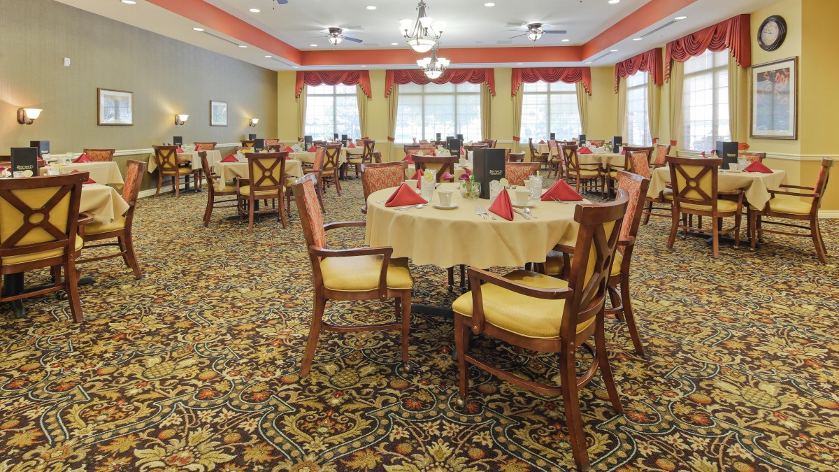 A spacious and elegantly decorated dining room with neatly arranged tables and chairs.