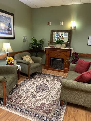 A cozy waiting area featuring comfortable furniture, a warm fireplace, and inviting decor.