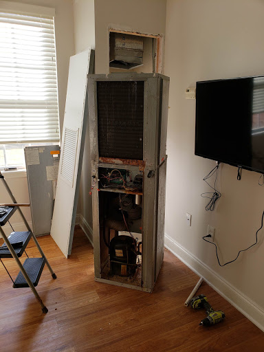 An unfinished room with a partially installed appliance next to a television.