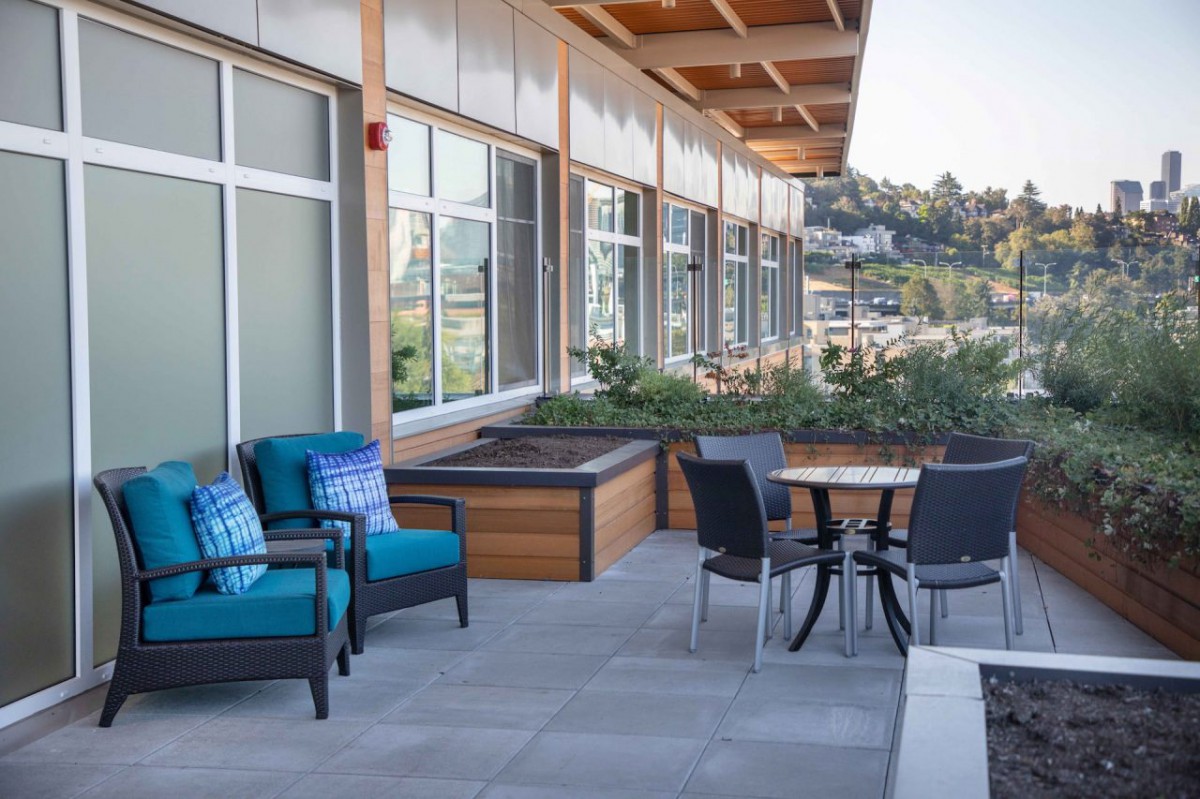 A modern outdoor patio with comfortable seating and a view of the city.