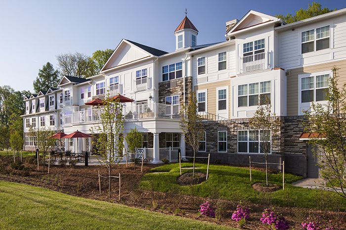 A well-maintained residential building with a landscaped garden and clear blue sky.