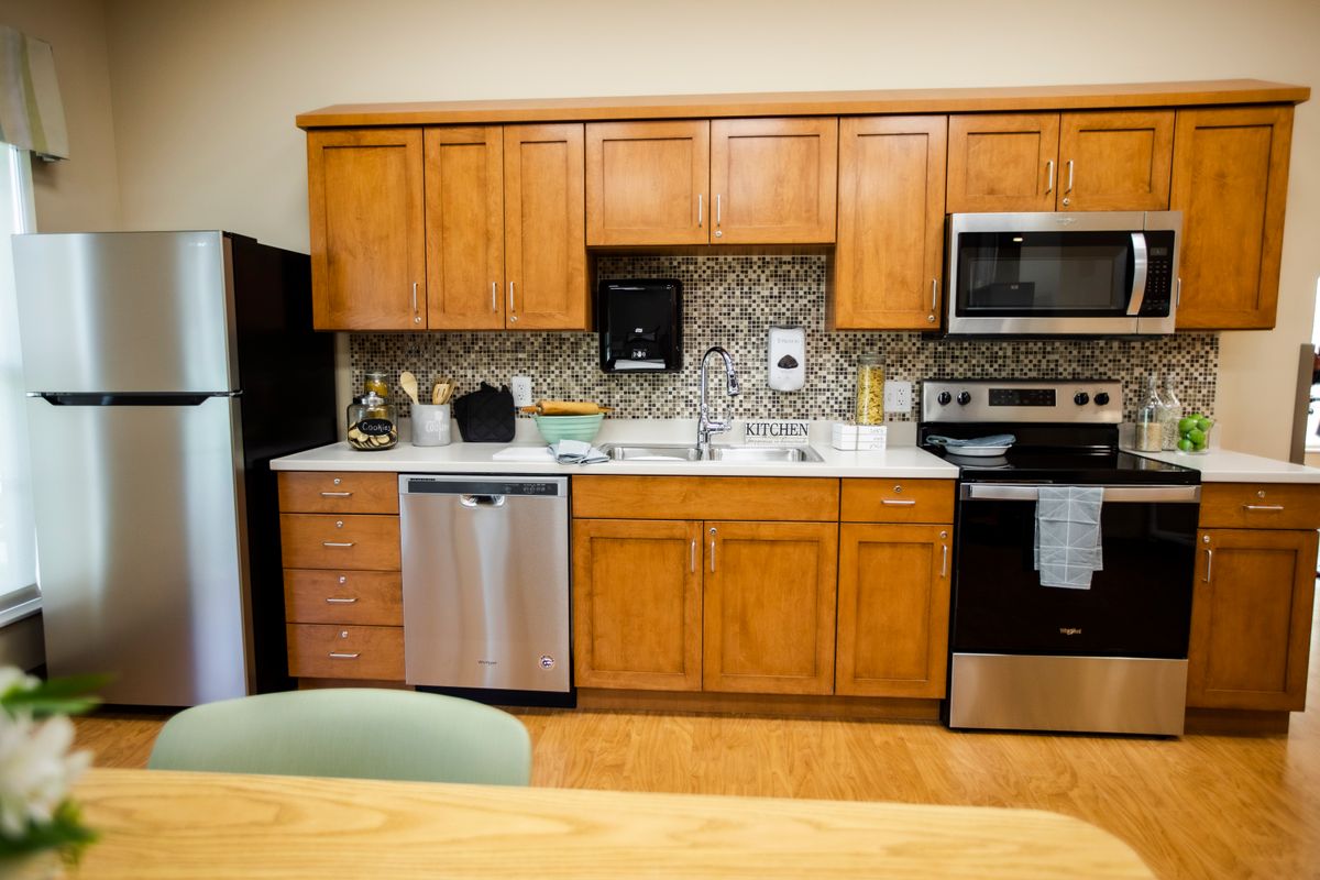 A modern kitchen featuring wooden cabinets, stainless steel appliances, and a stylish backsplash.