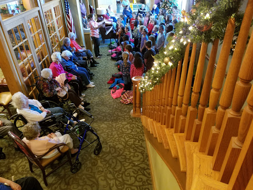 A joyful gathering of seniors and children participating in a performance, surrounded by a festive atmosphere.