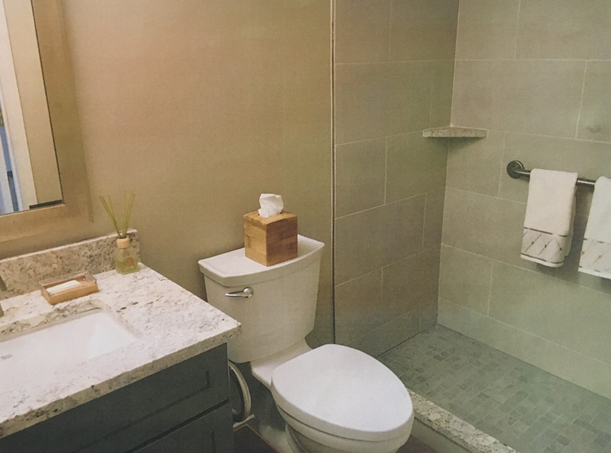 A modern bathroom with a toilet, shower, and sink.