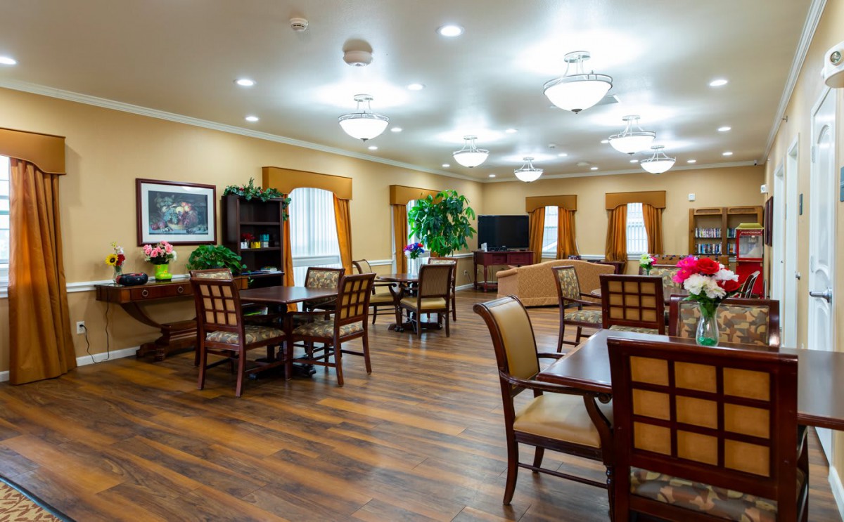 A well-lit dining area with tables and chairs arranged neatly, featuring elegant lighting fixtures and tasteful decor.