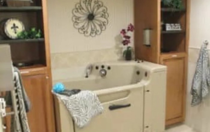 A walk-in tub designed for accessibility, featuring a towel and decorative flowers.