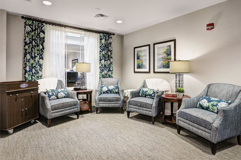 A cozy and elegantly decorated living room with armchairs and lamps.