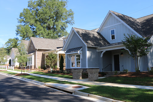 A picturesque view of a suburban neighborhood featuring modern houses under a clear blue sky.