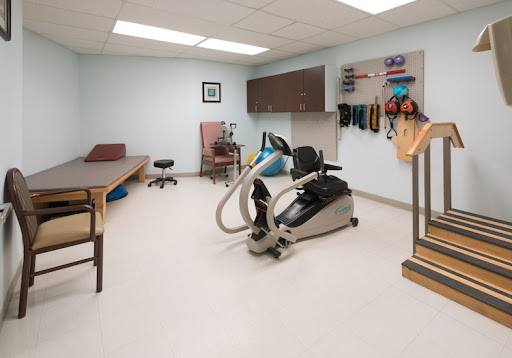 A well-equipped physical therapy room featuring exercise equipment and rehabilitation tools.