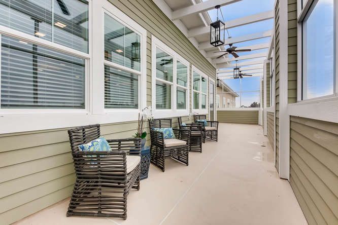 A modern outdoor patio with comfortable seating and ceiling fans.