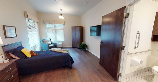 A cozy and modern bedroom featuring a comfortable bed, wooden furniture, and ample natural light.