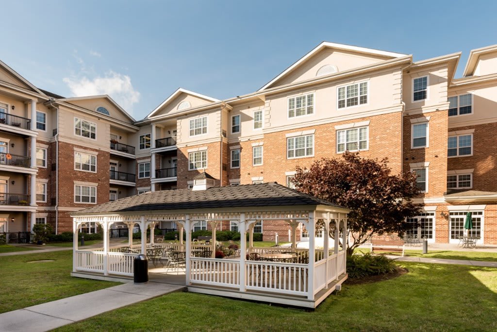 A modern apartment complex with a gazebo in the courtyard.