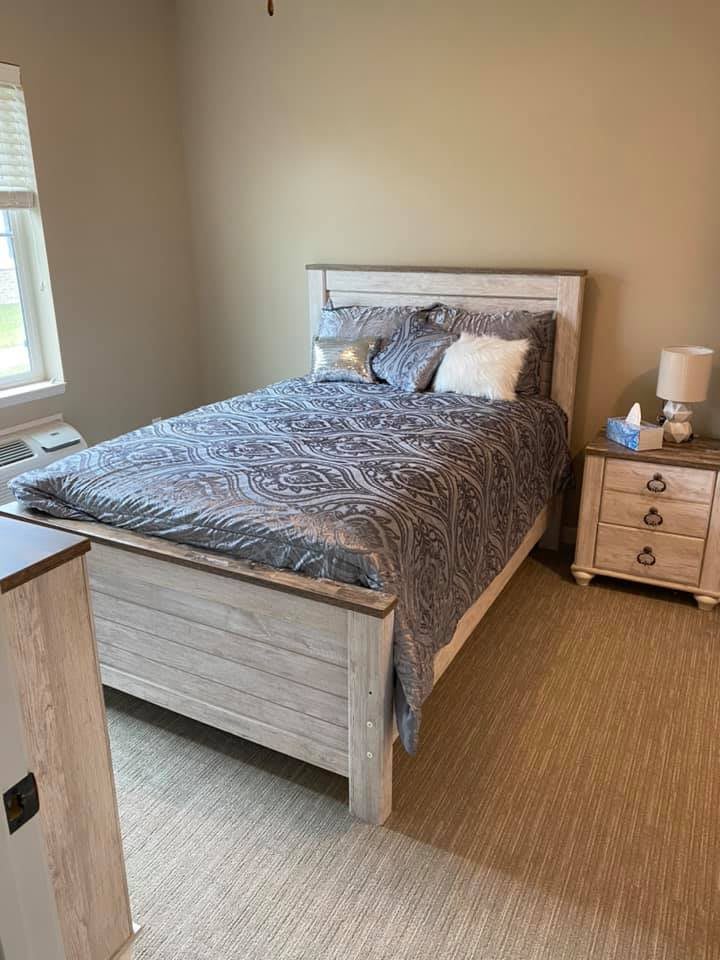 A cozy bedroom with a neatly made bed and bedside table.
