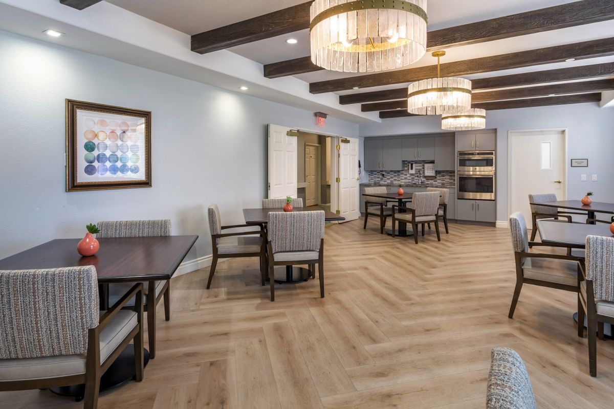 A modern dining area with elegant lighting and wooden flooring.