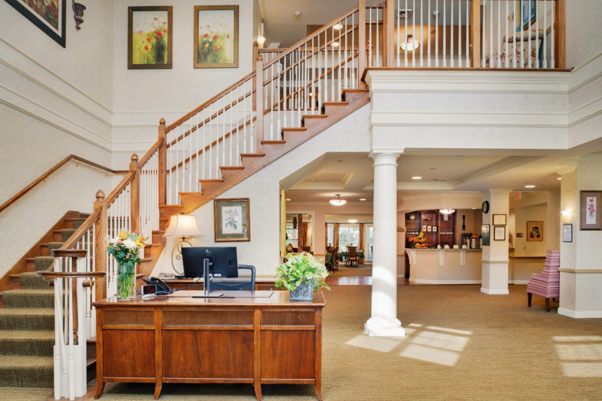 A well-decorated interior reception area with a wooden desk and staircase.