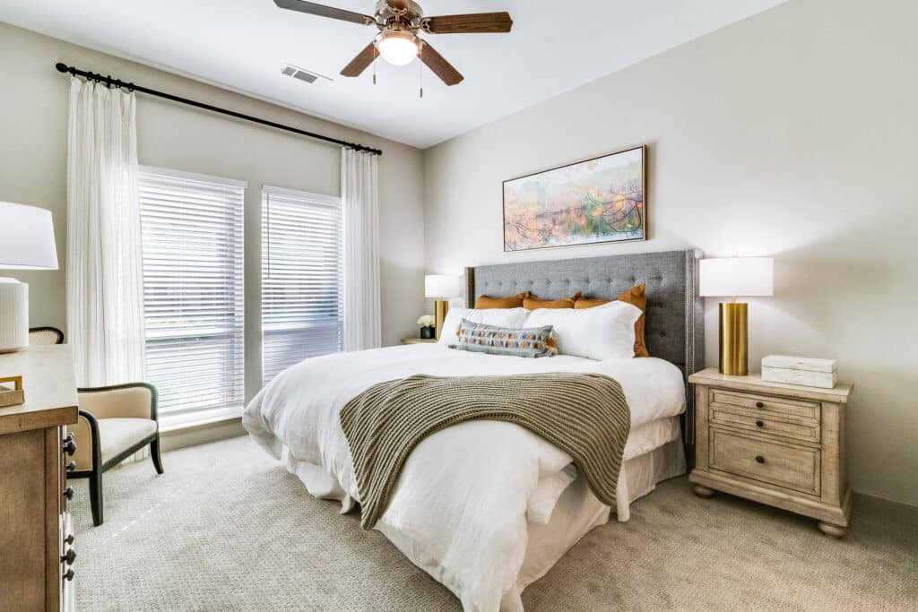 A modern bedroom with a comfortable bed, stylish decor, and ample natural light.