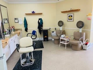 A cozy beauty salon interior with styling chairs and hair dryers.