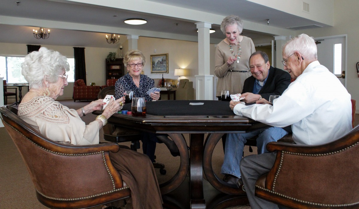 A group of seniors enjoying a game of cards together indoors.