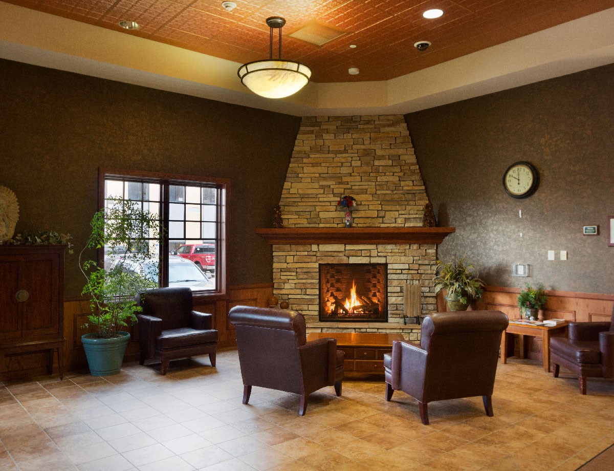 A cozy lobby features a stone fireplace with comfortable seating and warm ambient lighting.