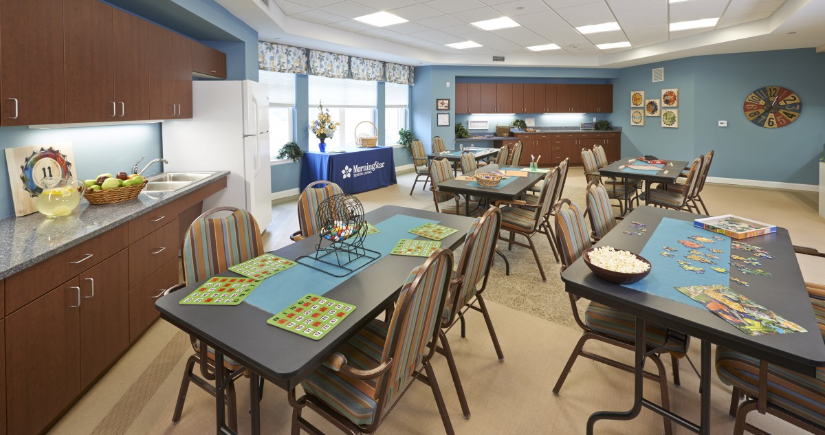 An inviting dining and meeting area with multiple tables and chairs arranged for a casual gathering.