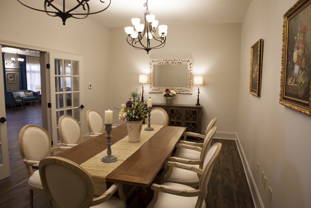 Elegant dining room with a wooden table, classic chairs, and a decorative chandelier.