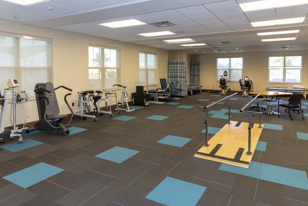 A gymnasium featuring various exercise equipment set up for fitness and rehabilitation activities.