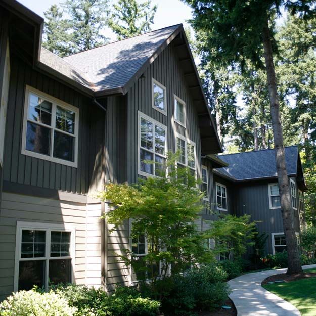 A charming residential house surrounded by lush trees and greenery.