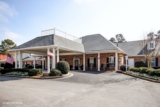 A brick bank building with a drive-through and parking area.