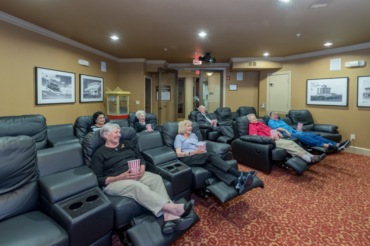 A group of people enjoying a movie in a comfortable home theater setting.