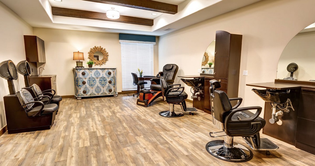 A chic and modern hair salon interior with stylish chairs and mirrors on a wooden floor.