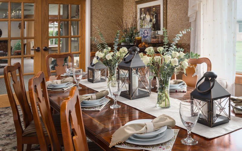 A beautifully set dining table adorned with flowers and lanterns, creating an elegant atmosphere.