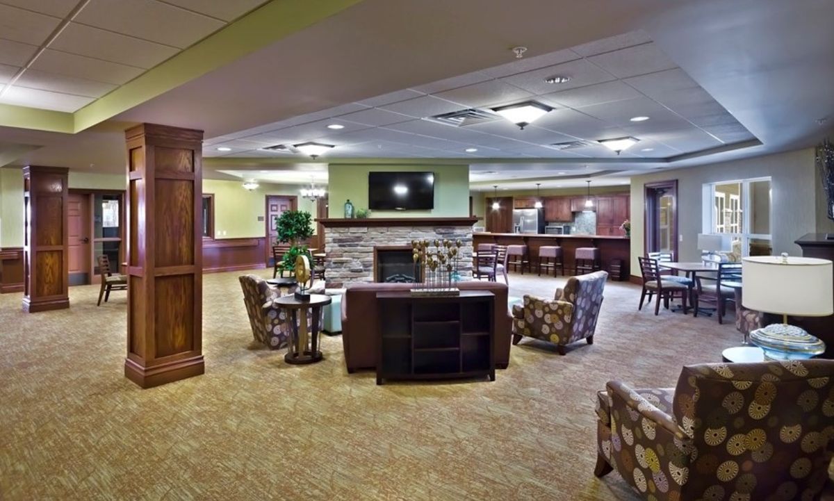 Spacious lounge area with modern decor and comfortable seating around a fireplace.