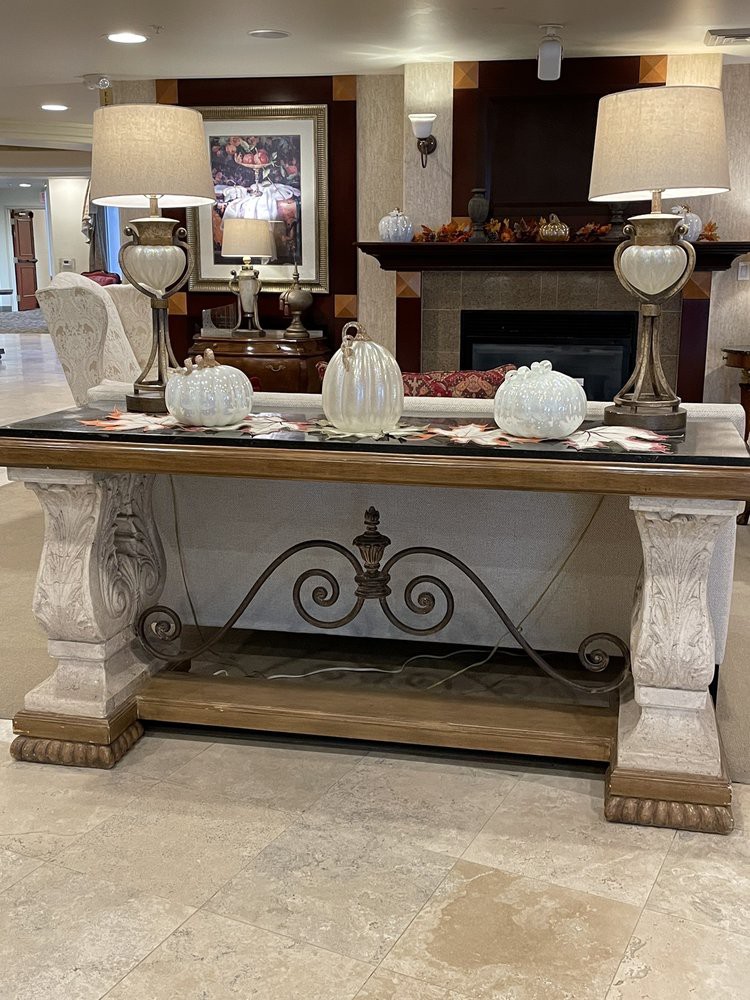 An elegant console table with decorative pumpkins and lamps in a stylish living room.