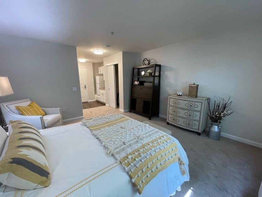 A cozy bedroom featuring a neatly made bed, elegant decor, and organized furniture.