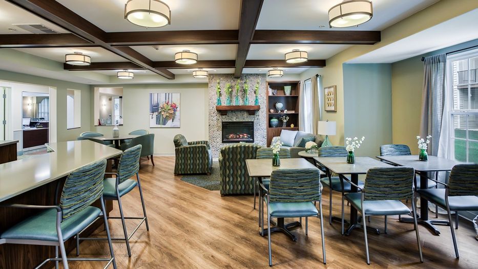 A modern lounge area featuring comfortable seating, a fireplace, and elegant lighting.