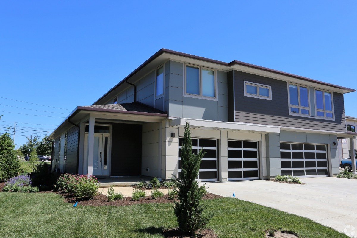 A modern two-story house with a well-maintained front yard and a double garage.