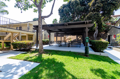 A serene outdoor pavilion surrounded by lush green grass and trees, perfect for gatherings or relaxation.