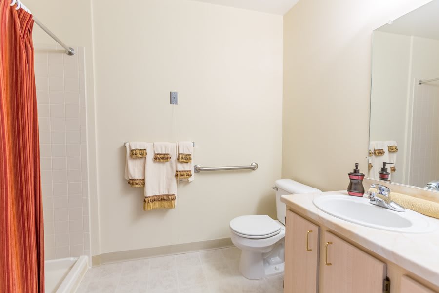 A clean and simple bathroom with a toilet, sink, and shower area.