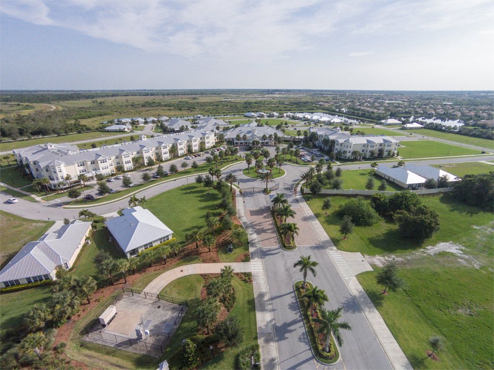 Aerial view of a campus with buildings, roads, and lush greenery.