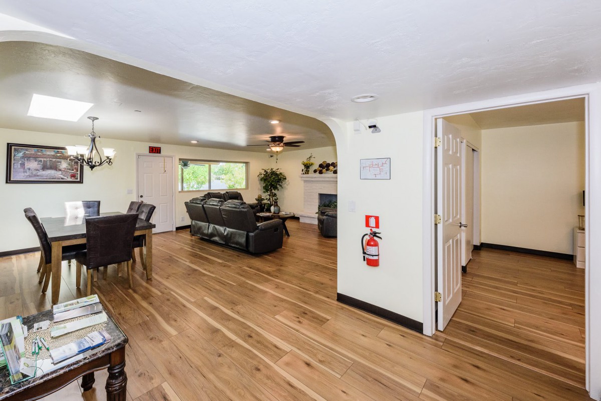 An open living and dining area with hardwood floors, featuring a comfortable sofa and a dining table.