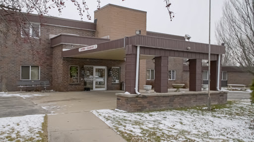 A view of the entrance to a building during winter, with some snow on the ground.