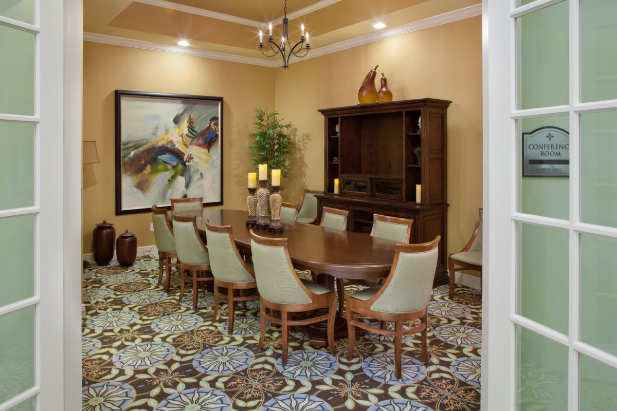 A well-decorated dining room with an elegant table set, artwork, and ambient lighting.