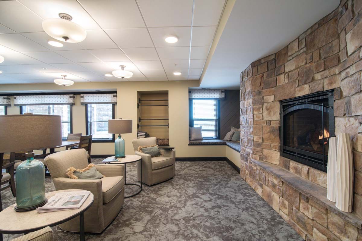 A cozy living room featuring a stone fireplace and comfortable seating.