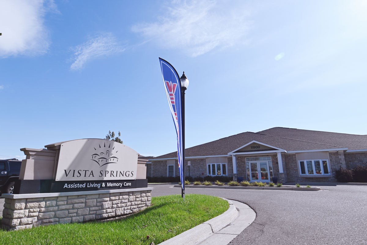 Exterior view of a building with signage and a flag outside.