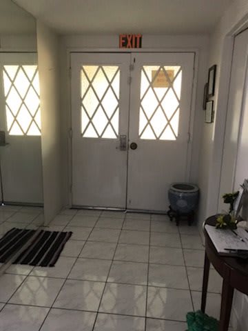 A tiled entrance area with double doors and an exit sign above.