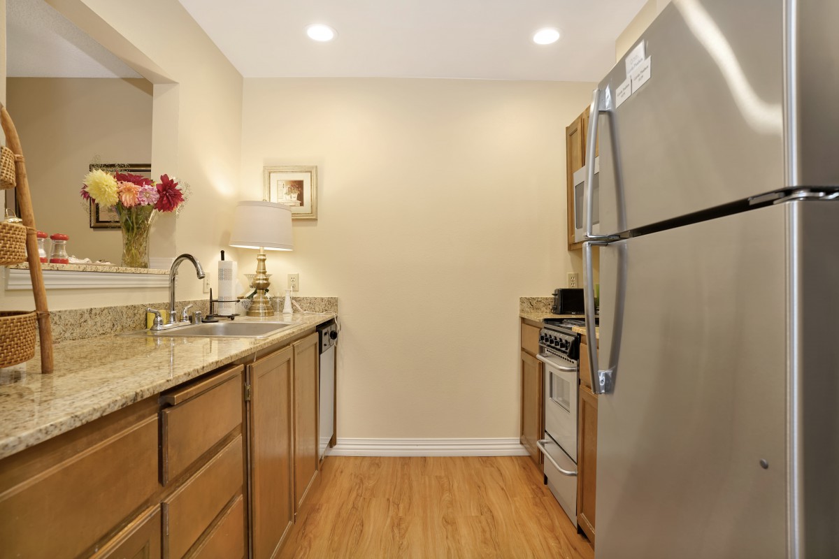 A modern kitchen with wooden cabinets and stainless steel appliances.