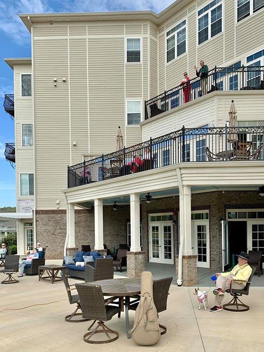People relaxing on the patio and balconies of a residential building.