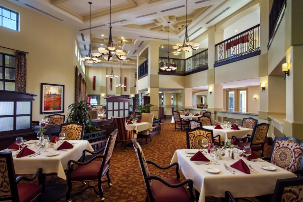 A well-decorated restaurant interior with elegant chandeliers and neatly arranged dining tables.