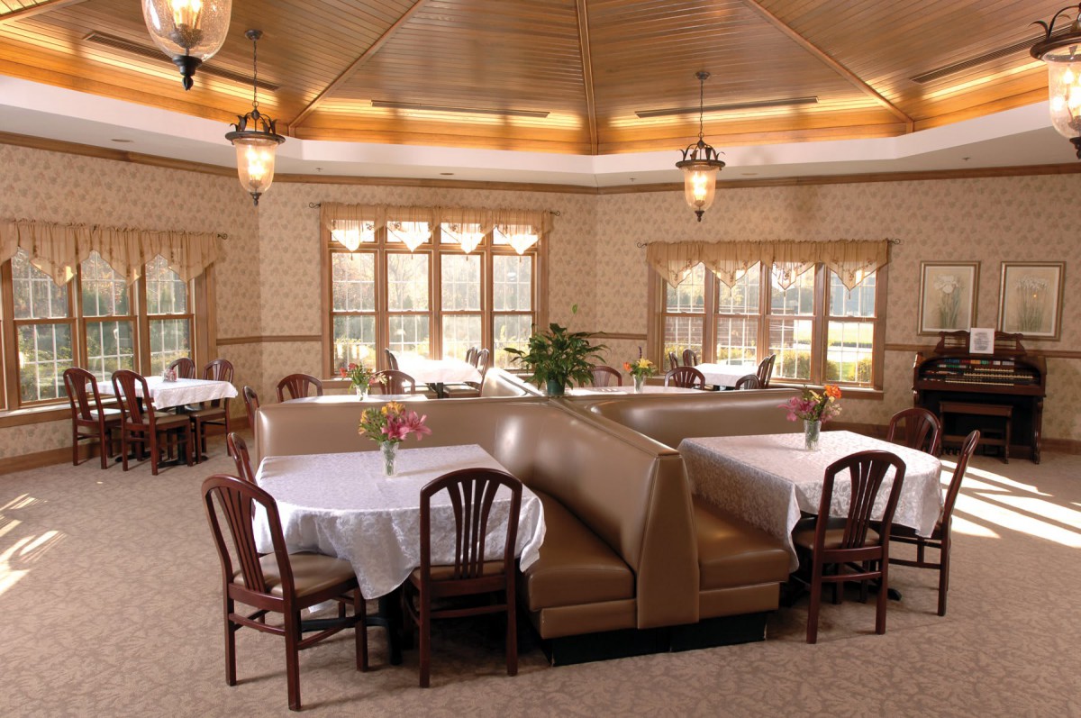 A cozy restaurant dining area featuring booths and tables with elegant lighting.
