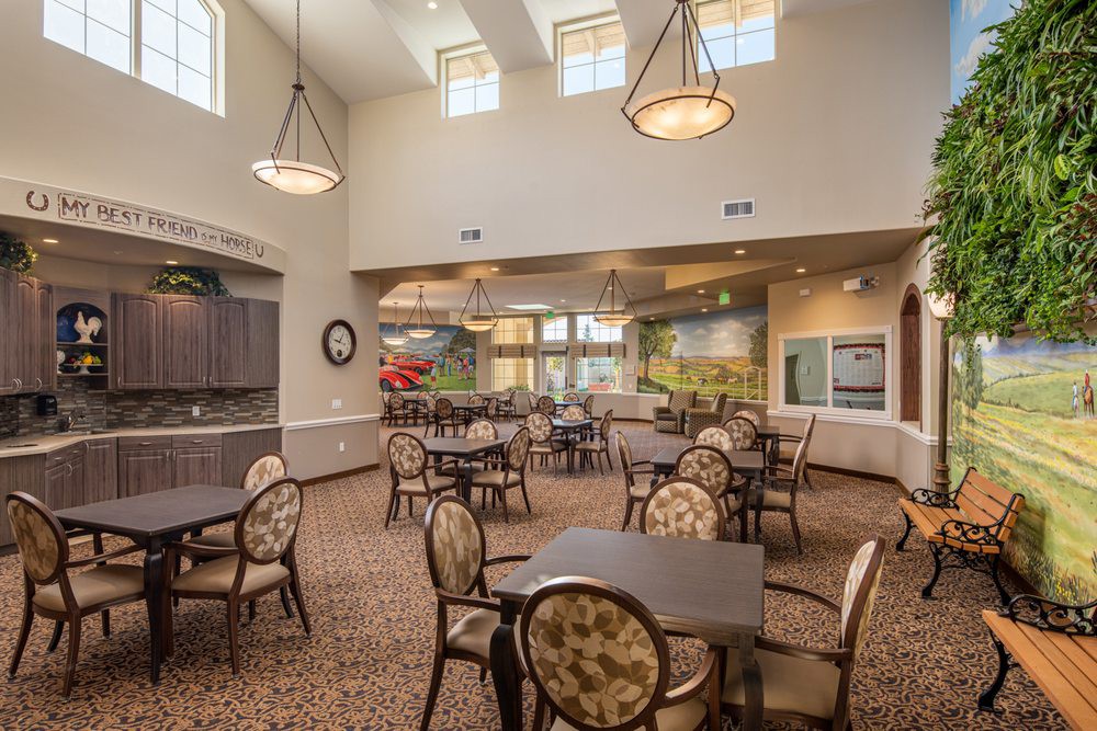 A well-lit dining area with multiple tables and chairs, featuring elegant lighting and decor.